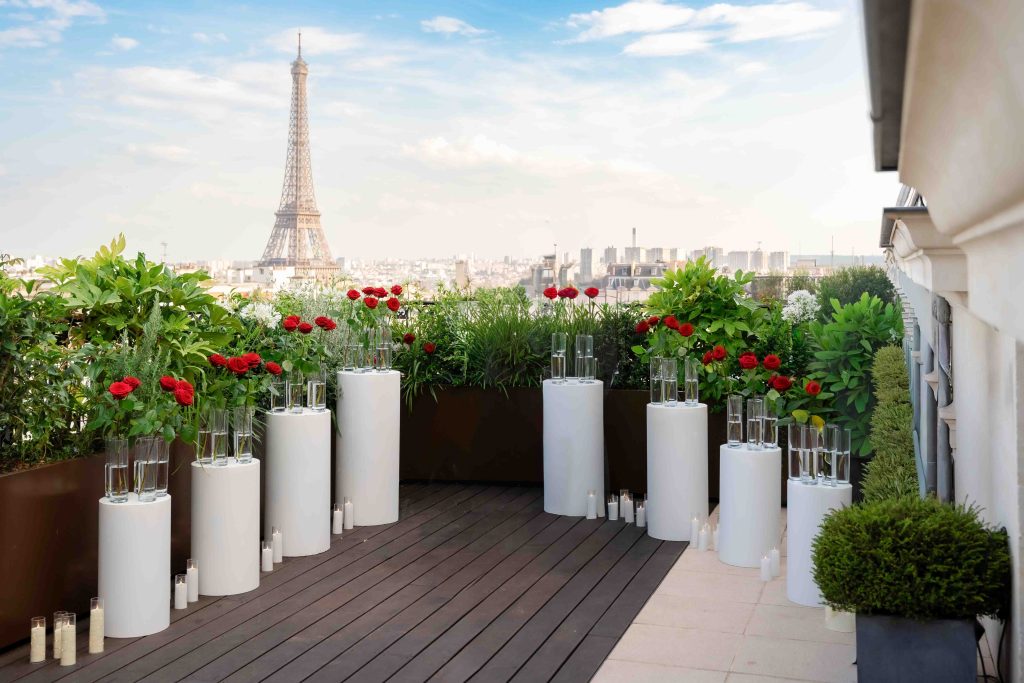 White Display Columns Rental Paris styled with red roses and glass vases on a rooftop facing the Eiffel Tower