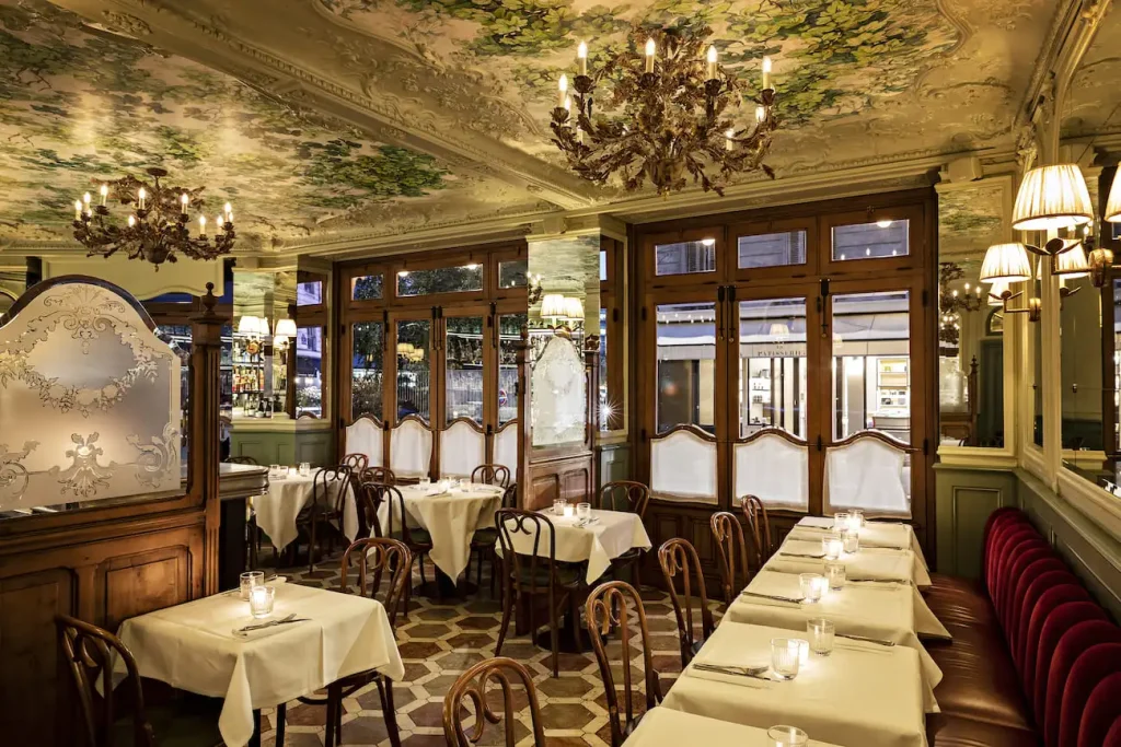 Historic dining room at Le Chardenoux in Paris 11th arrondissement, with engraved ceiling and marble bar
